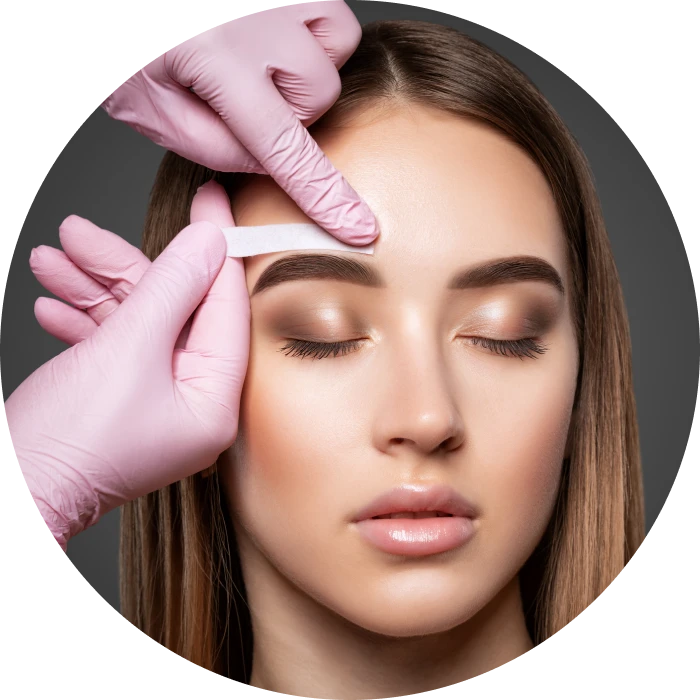 Woman receiving eyebrow waxing treatment