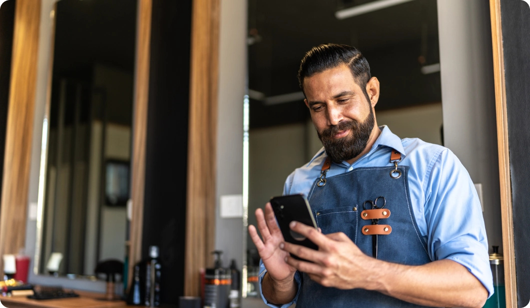 Hairdresser texting in barbershop
